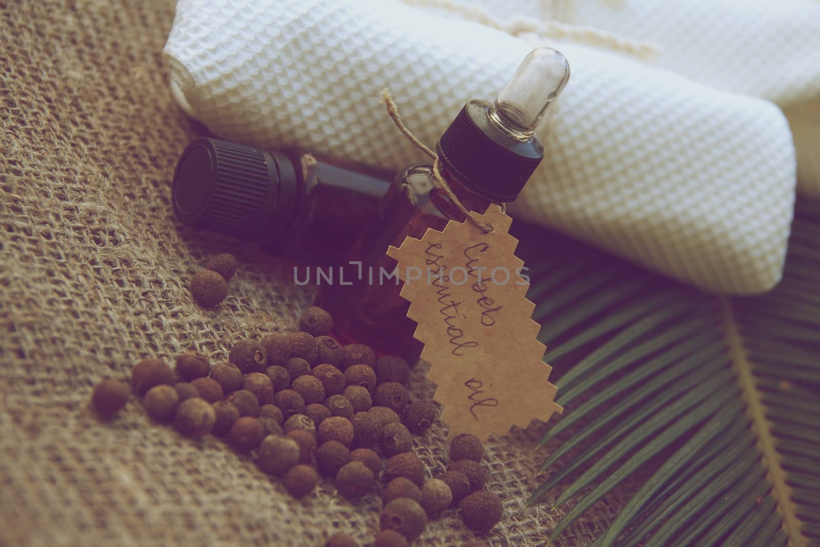 A bottle of cubeb essential oil on the sackcloth. Vintage