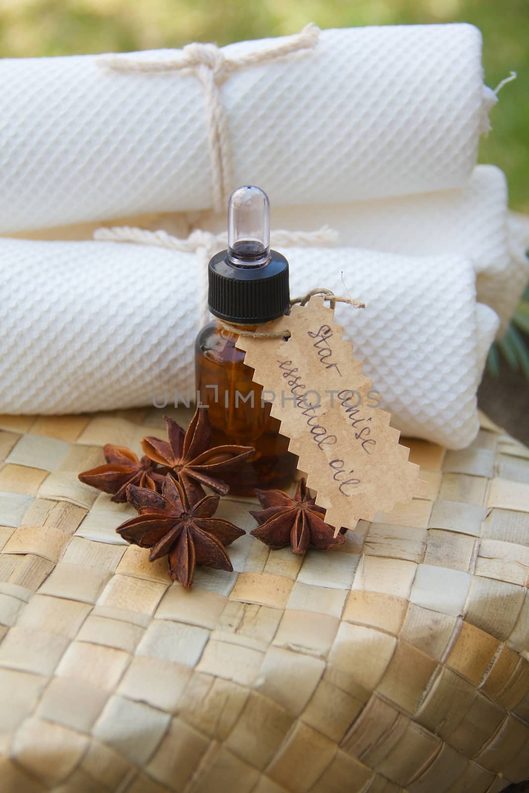 A bottle of star anise essential oil on the woven surface