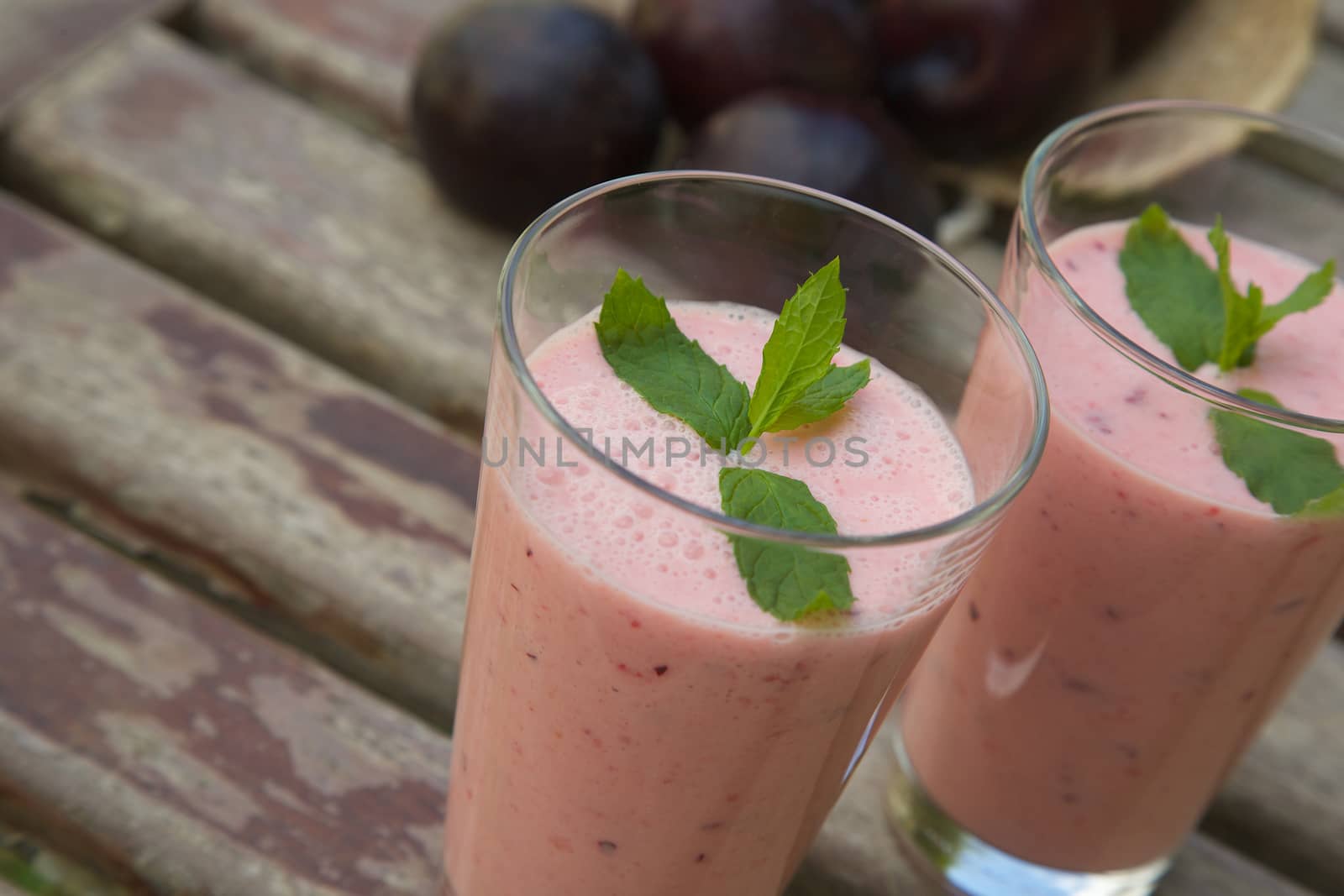 Two glasses of homemade plum smoothie with peppermint by tolikoff_photography
