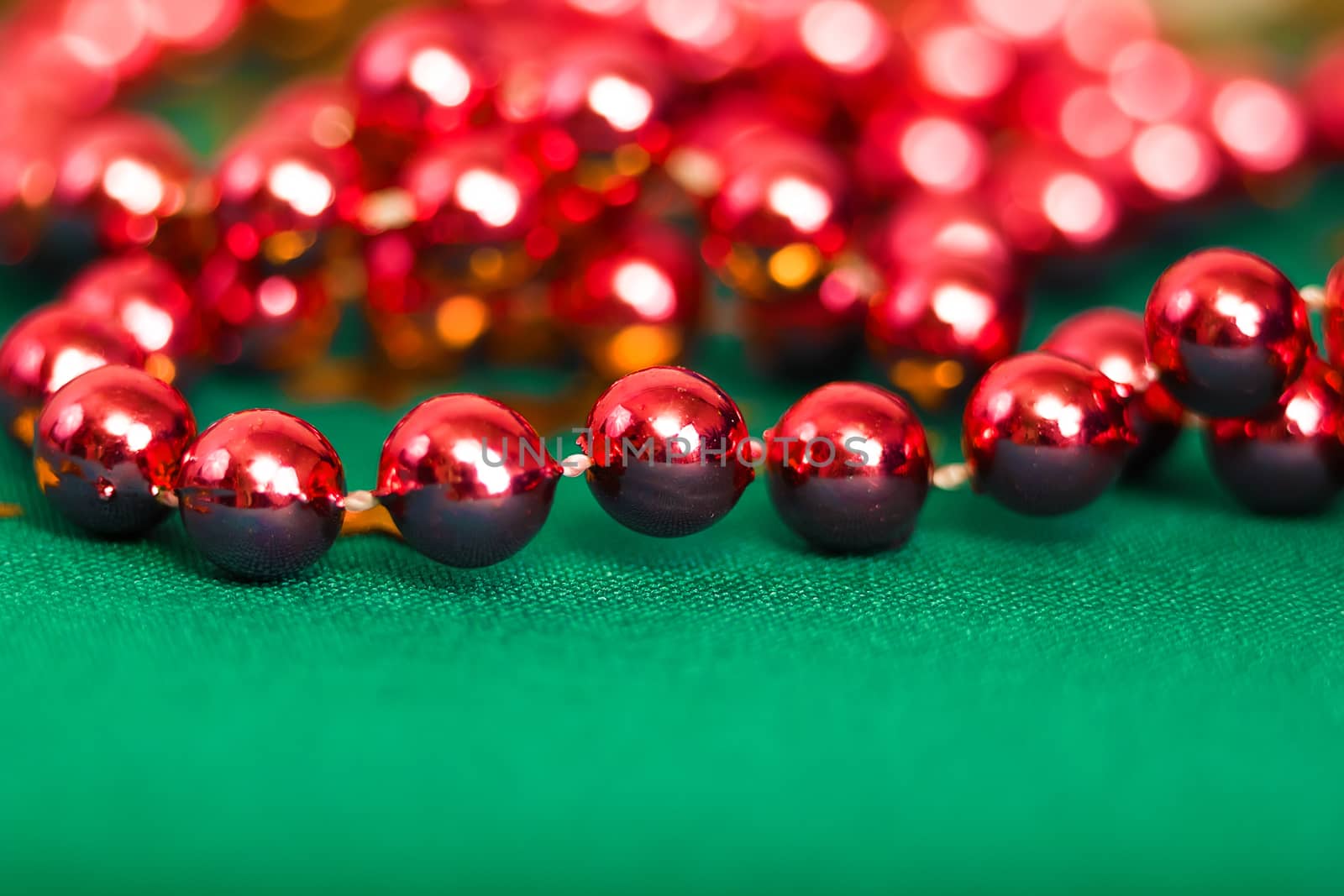 Christmas card. Red beads on green cloth