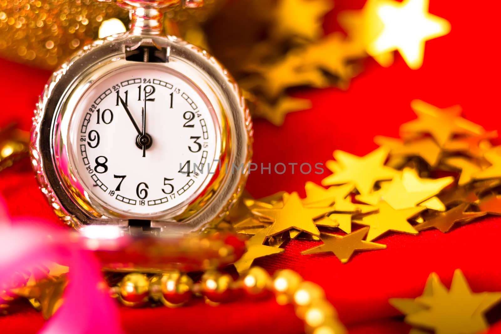 Christmas card. Silver vintage pocket watch on a red background with golden decorations