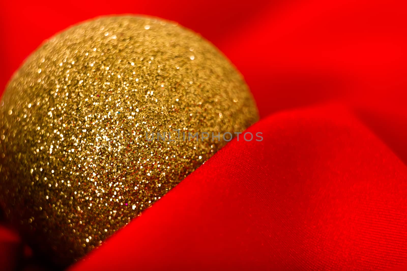 Christmas golden ball on a red cloth. macro