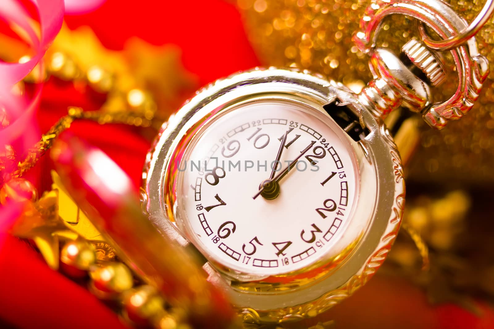 Christmas card. Silver vintage pocket watch on a red background with golden decorations
