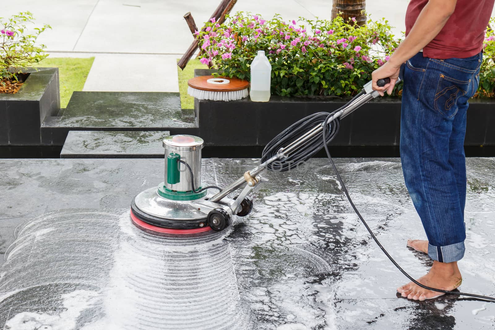 Thai people cleaning black granite floor with machine and chemical
