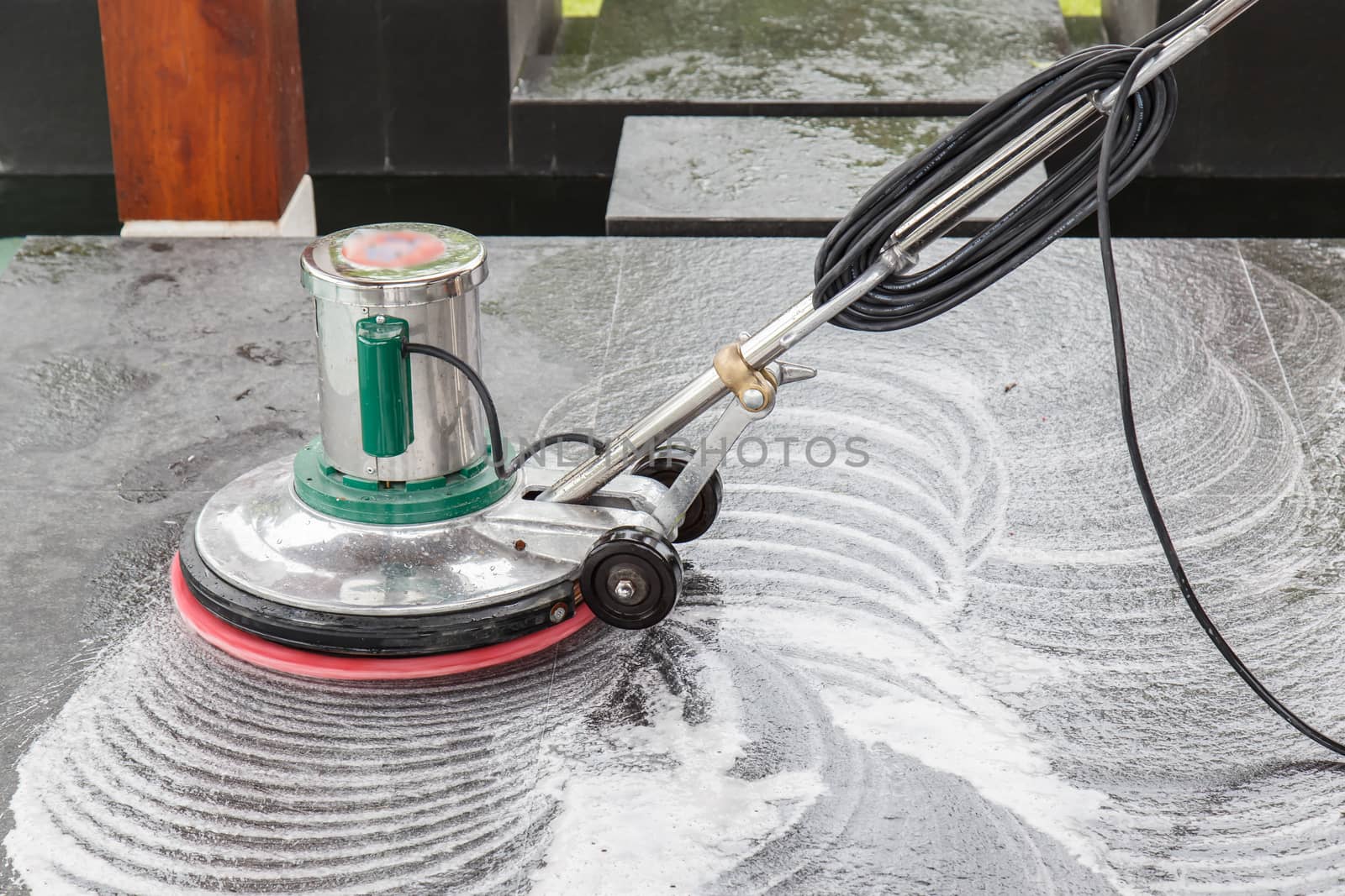 Thai people cleaning black granite floor with machine and chemical