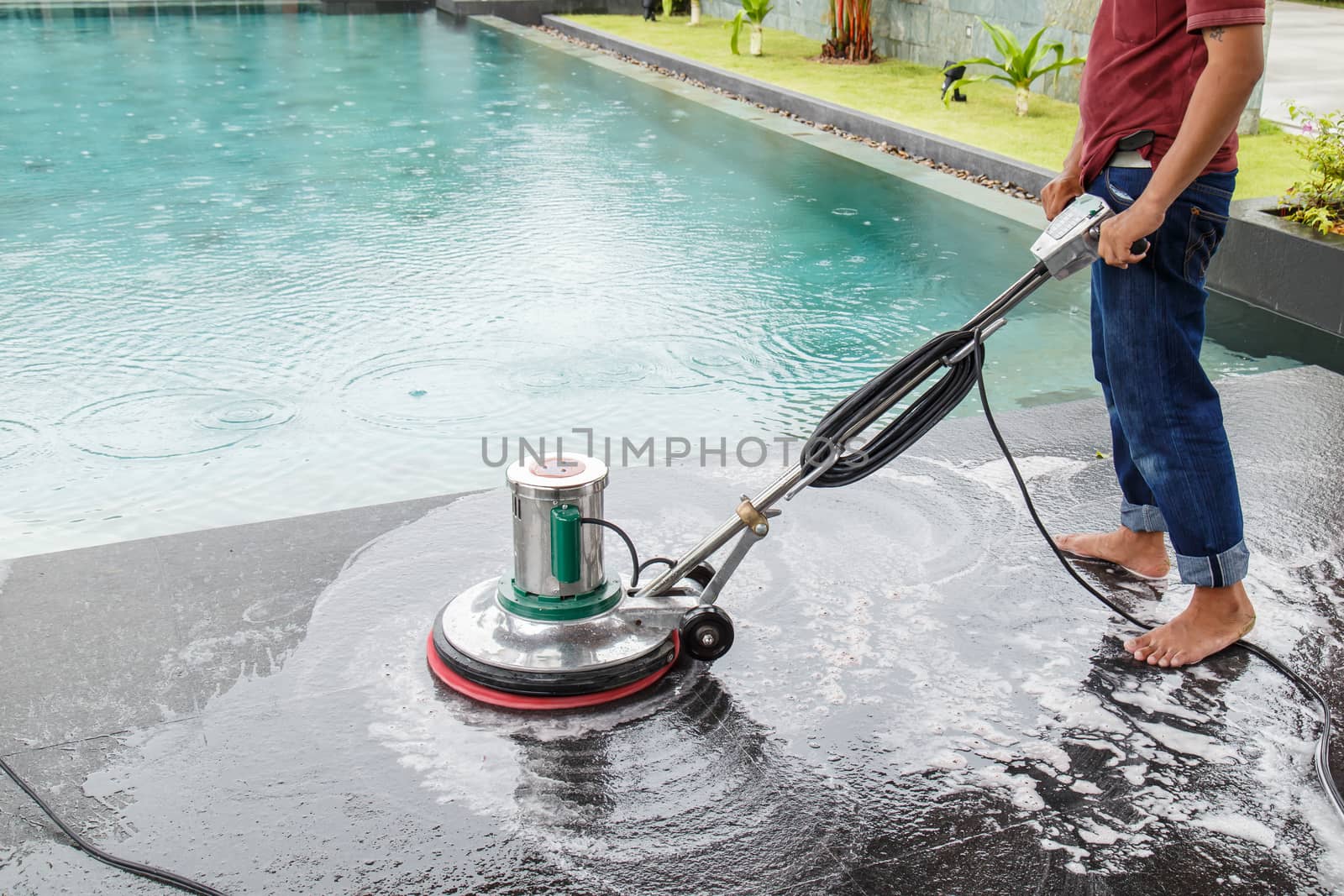 Thai people cleaning black granite floor with machine and chemical