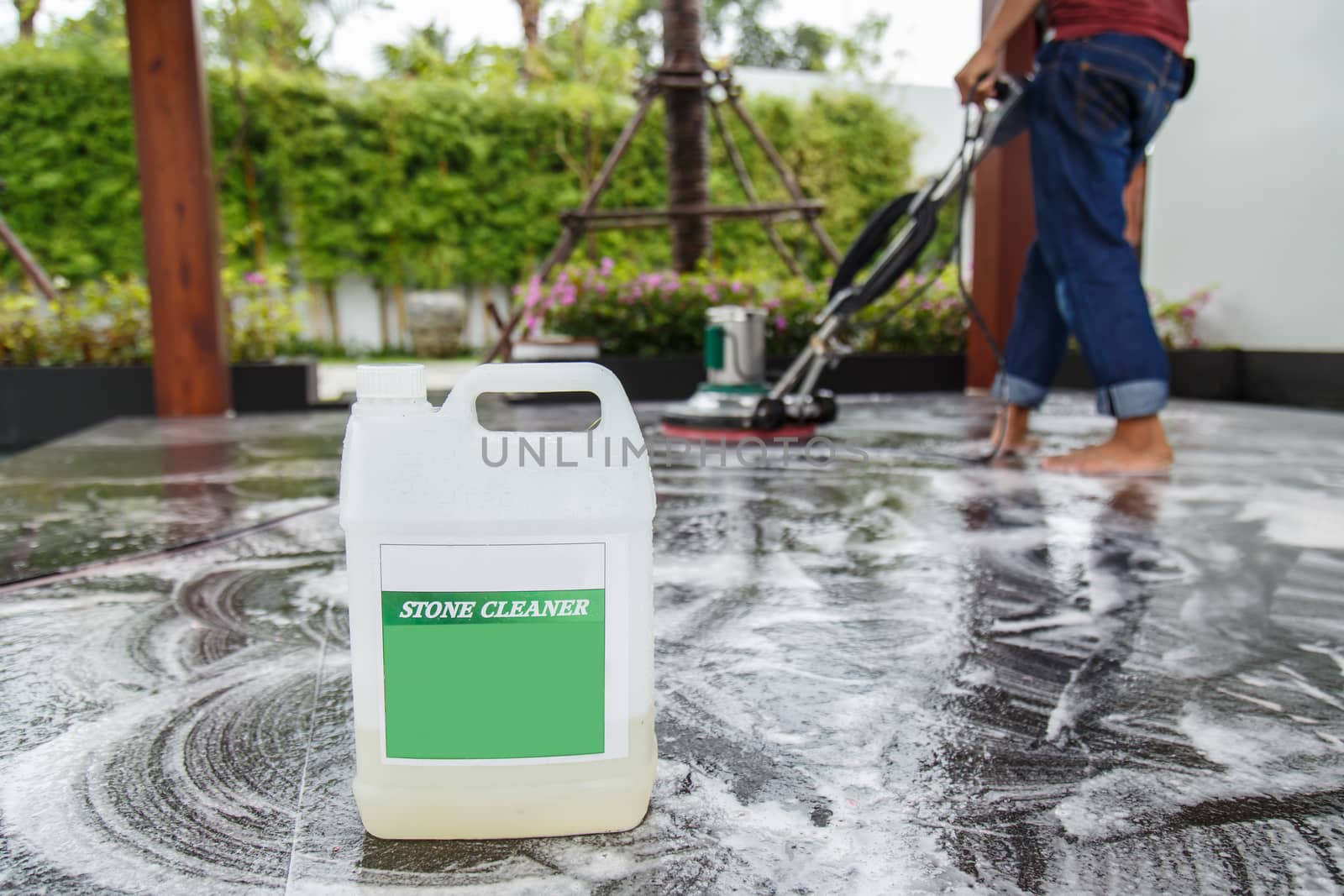 Thai people cleaning black granite floor with machine and chemical