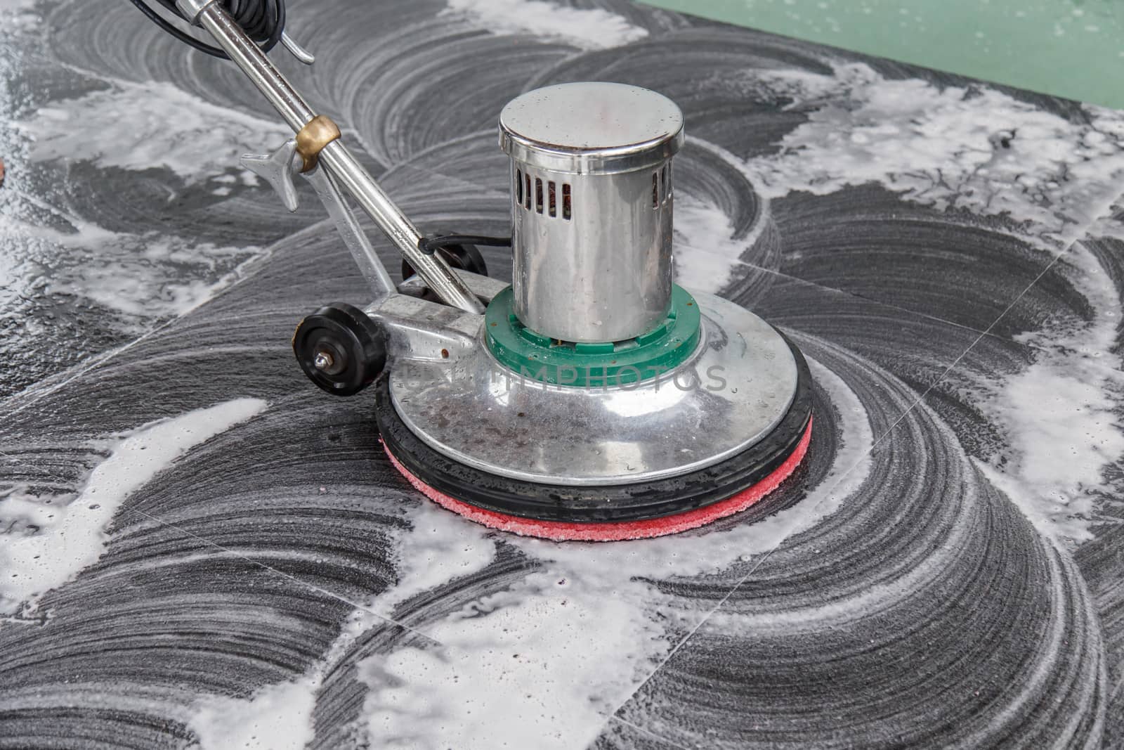 Thai people cleaning black granite floor with machine and chemical