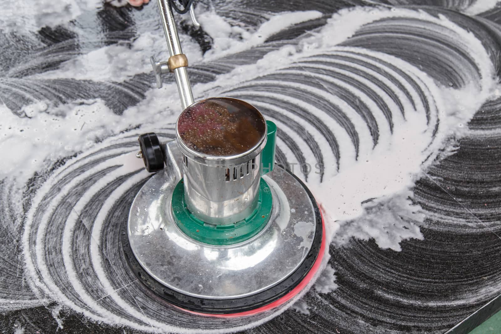 Thai people cleaning black granite floor with machine and chemical