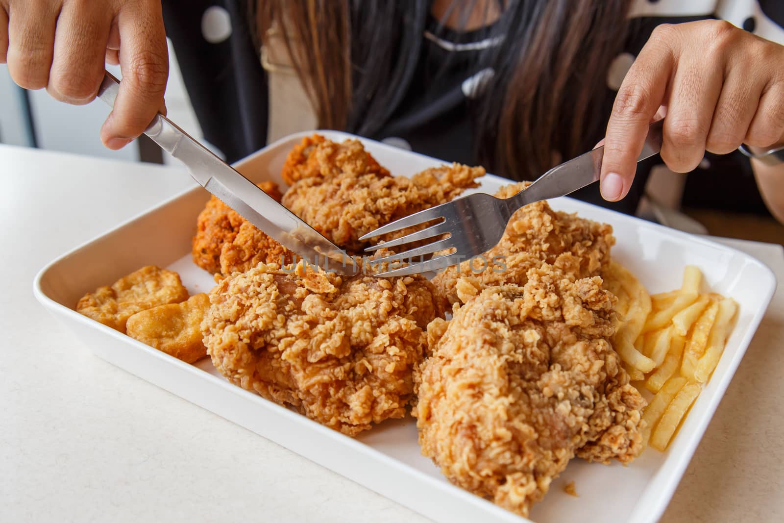 Hand holding Fried chicken and eating in the restaurant