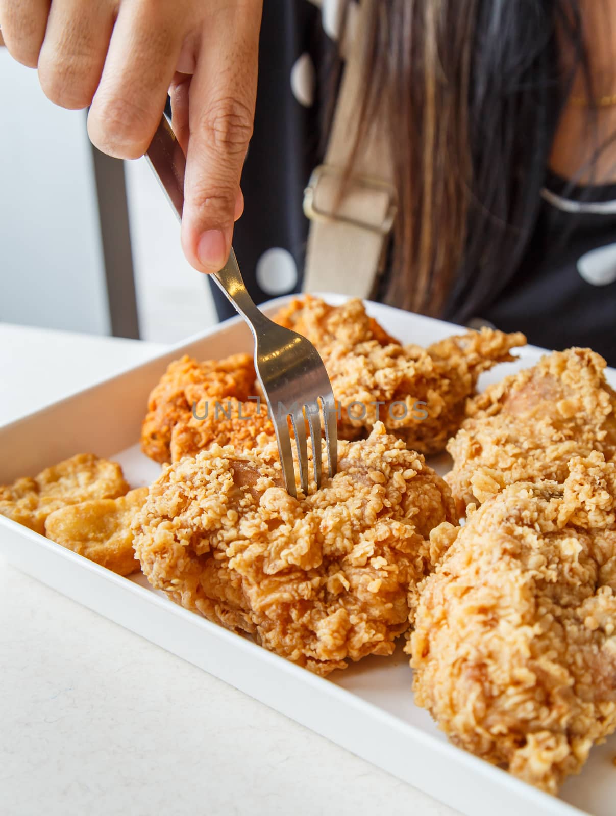 Hand holding Fried chicken and eating in the restaurant