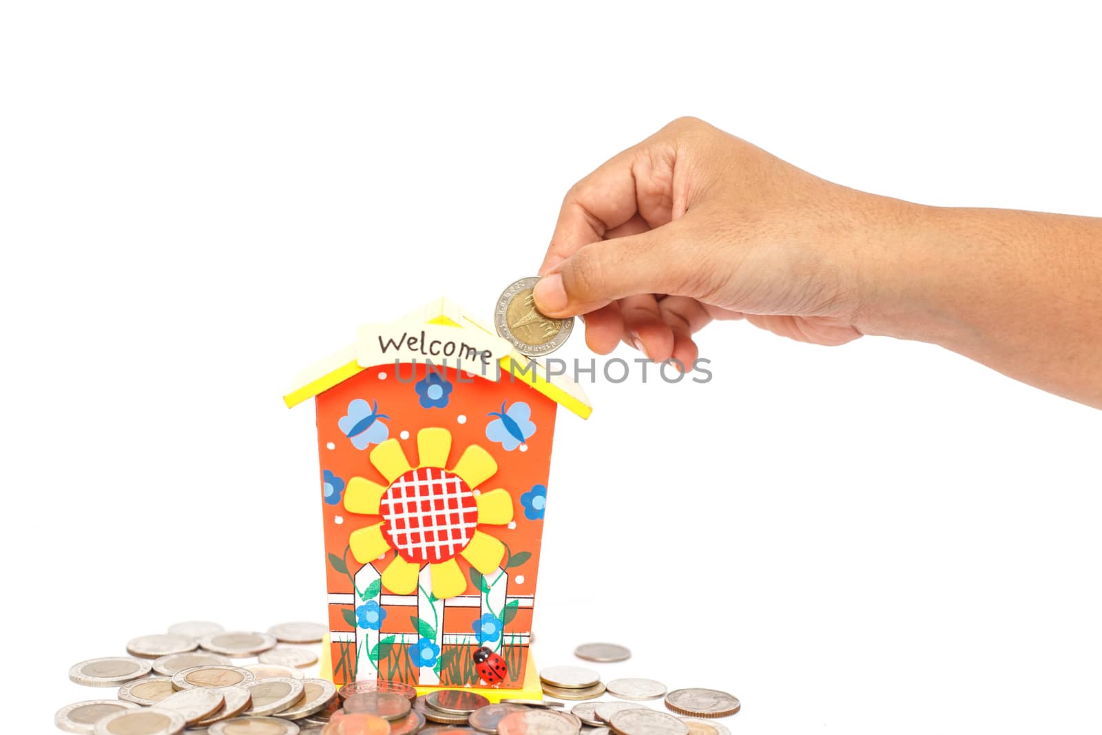 Hand holding coin and put in piggy bank isolated on white background