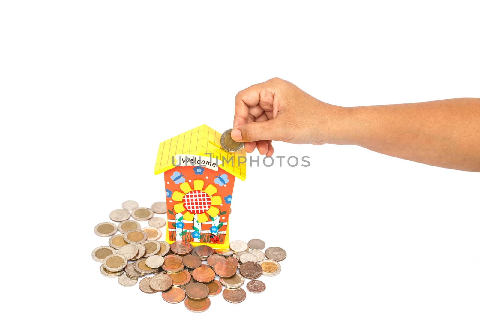 Hand holding coin and put in piggy bank isolated on white background