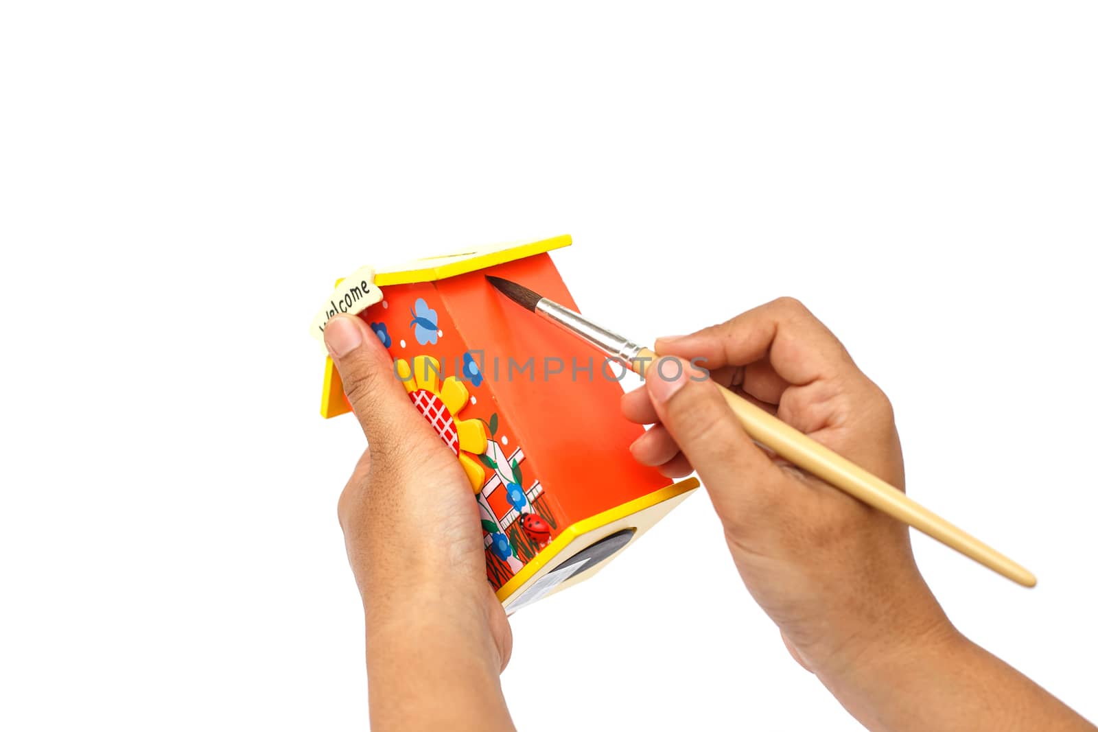 Hand holding paintbrush and painting isolated on white background