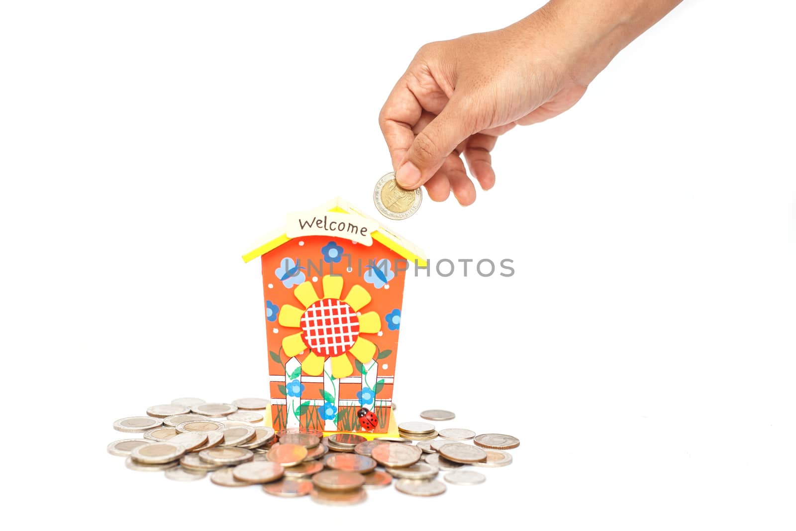 Hand holding coin and put in piggy bank isolated on white background