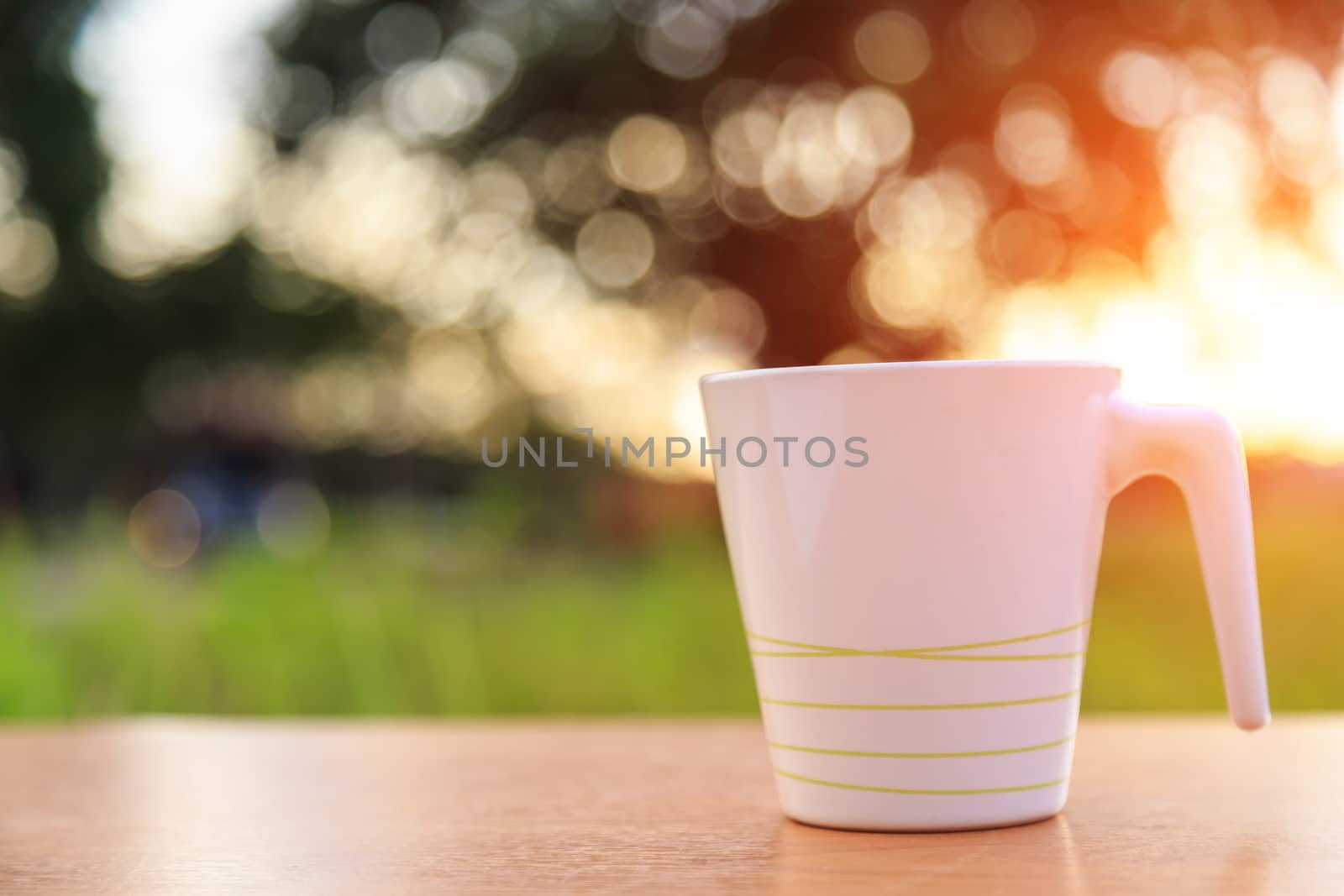 Coffee cup on the table in sunset time