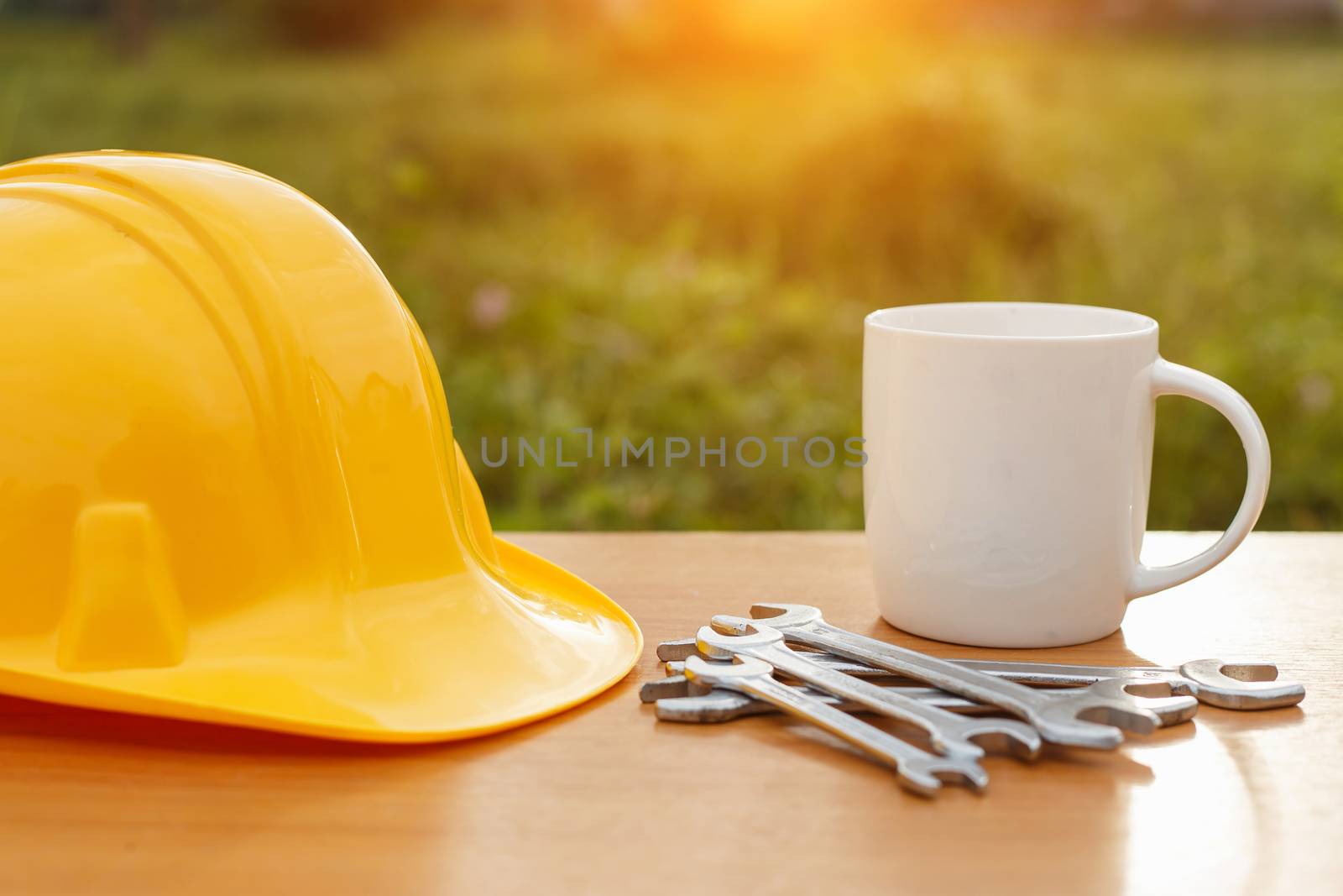 Close up coffee cup and safety helmet on the table