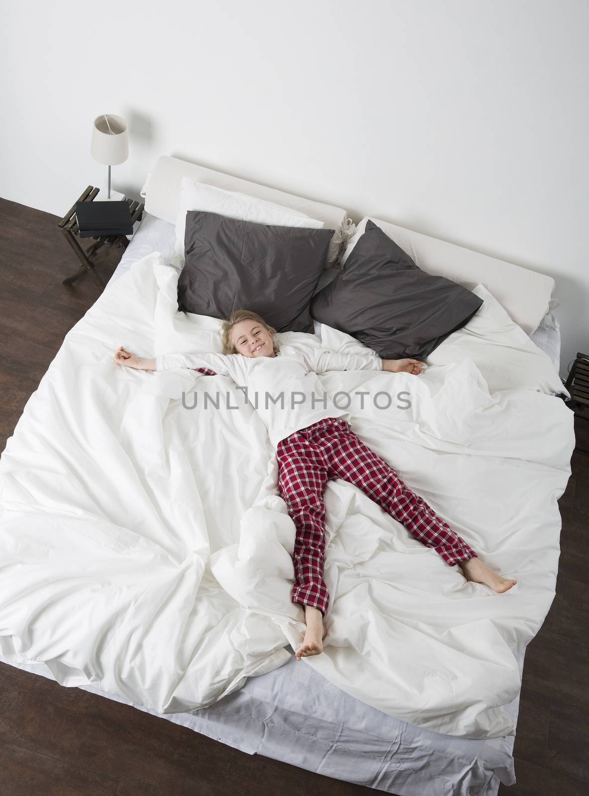 Happy Little Girl in a large bed from high angle view