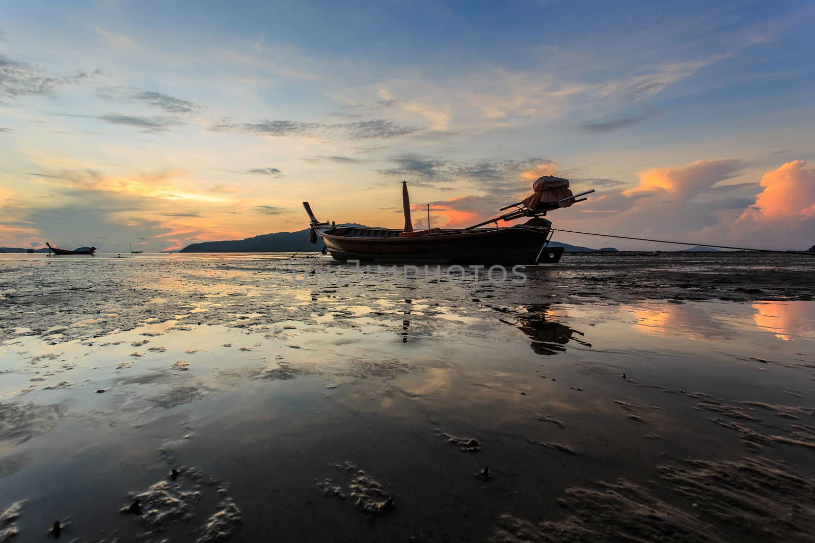 Silhouettes of longtail boat and sunrise in Phuket, Thailand
