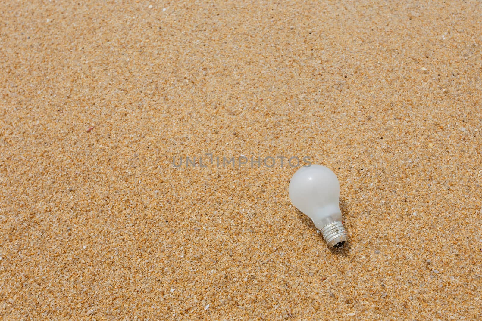 Old light bulb on the beach