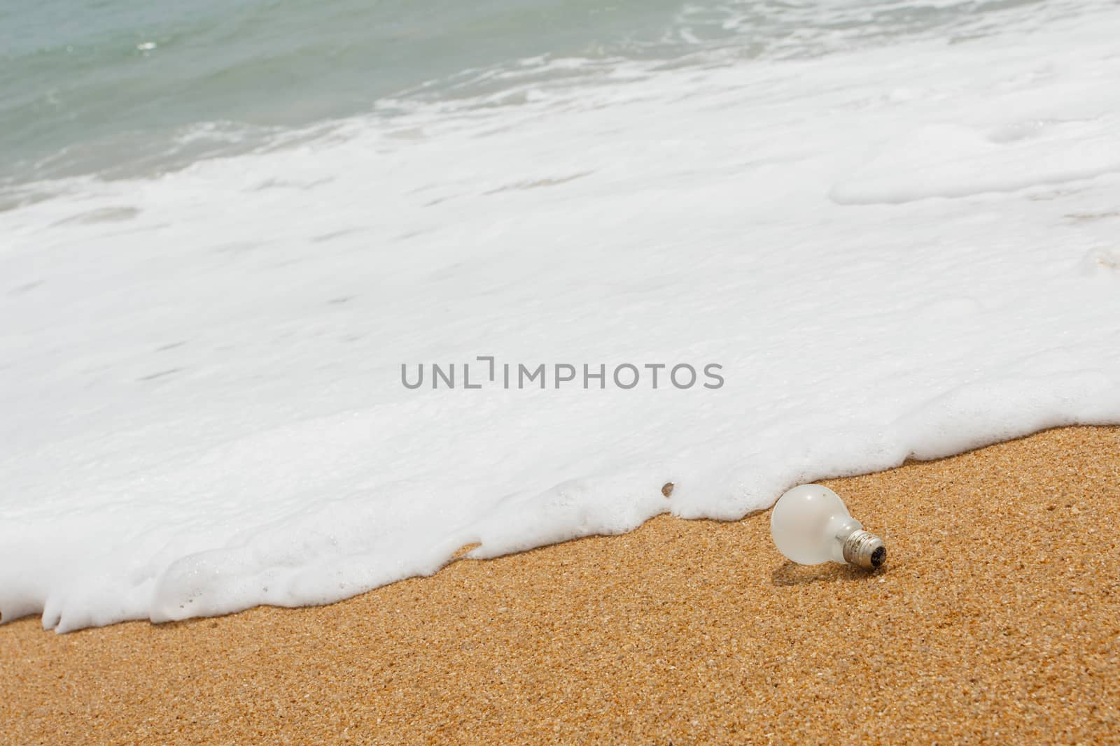 Old light bulb on the beach