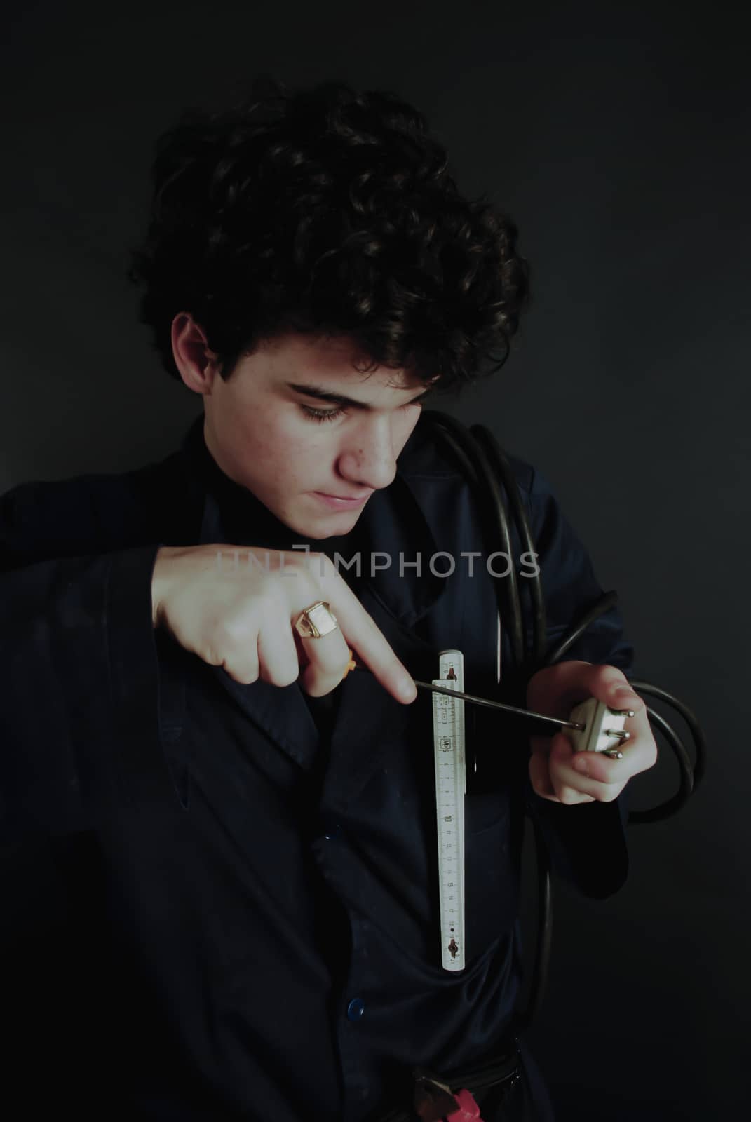 Young electician using his tools specifically fixing a socket with screwdriver