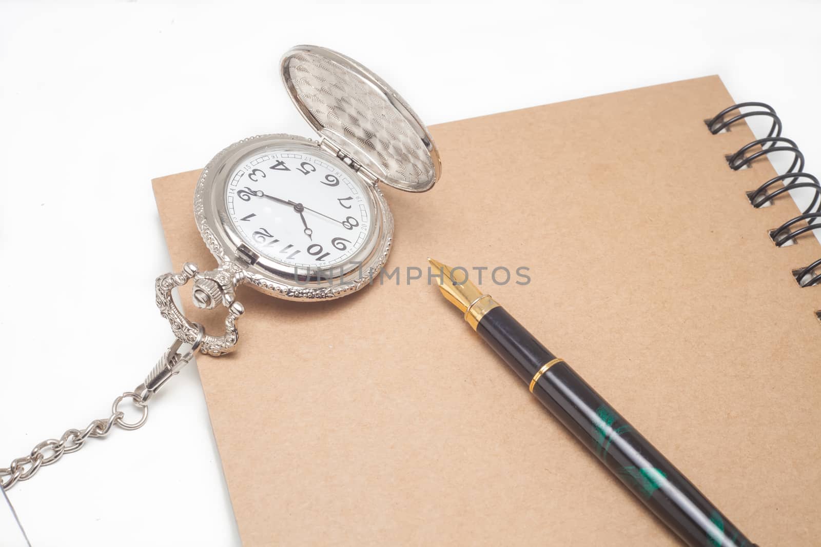 fountain pen and pocketwatch on book