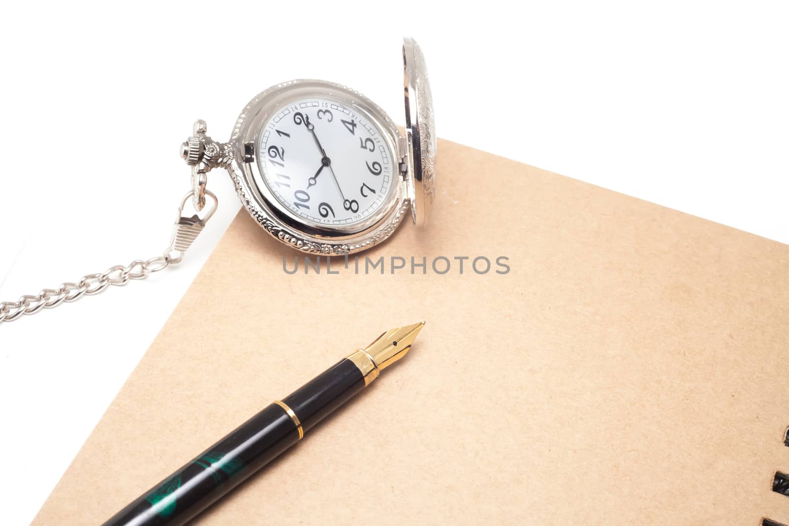 fountain pen and pocketwatch on book