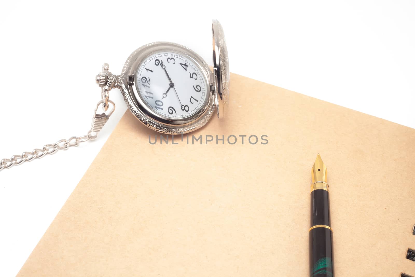 fountain pen and pocketwatch on book