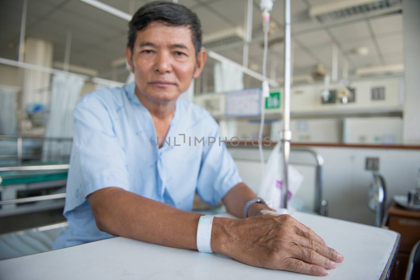 Patient with IV drip and hand tag in a hospital