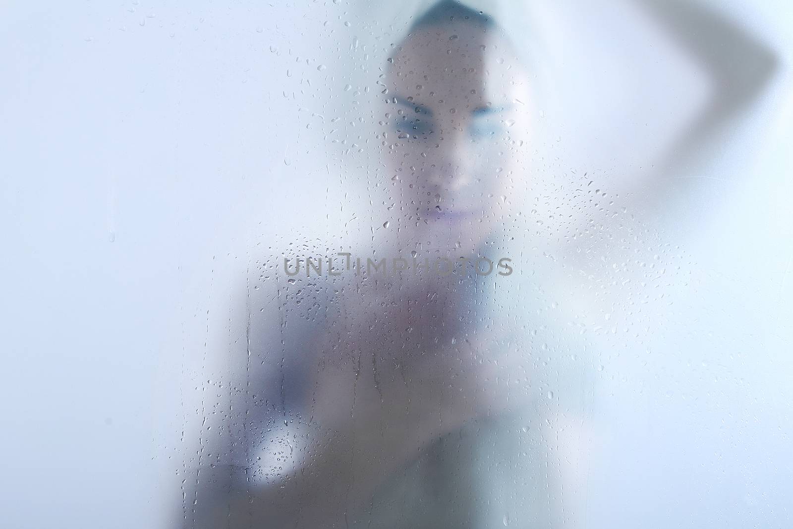A woman in the shower wipes body with a towel by robert_przybysz