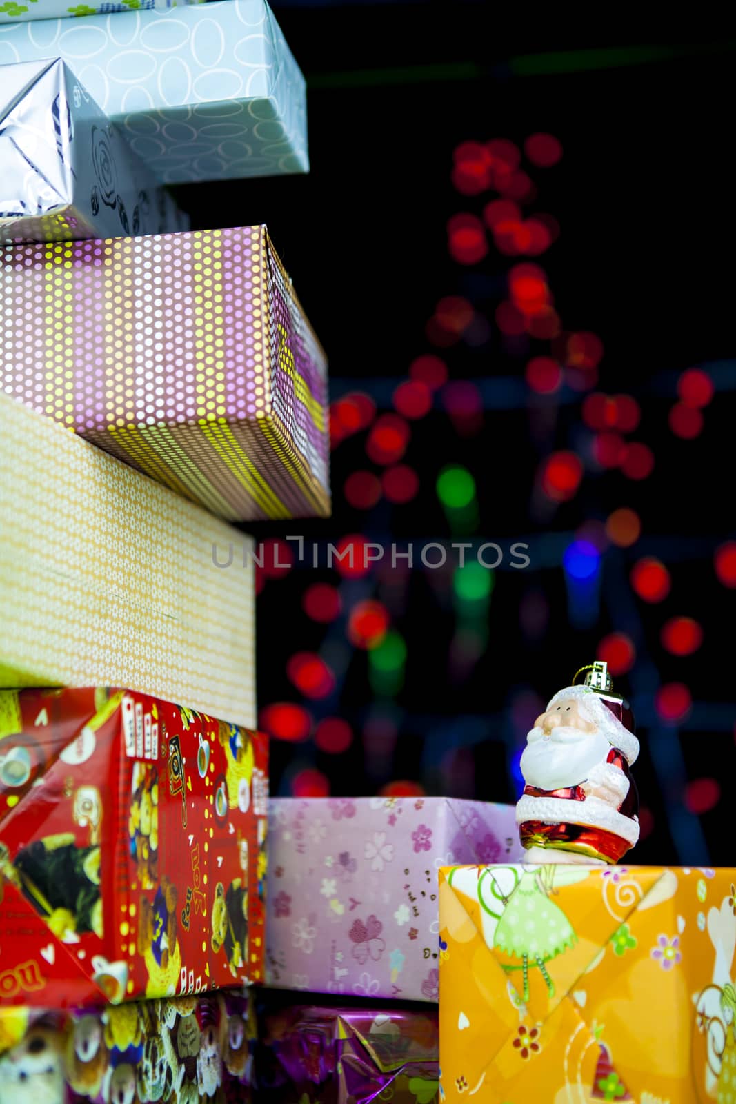 Christmas gift and Santa Claus with blurred light on background