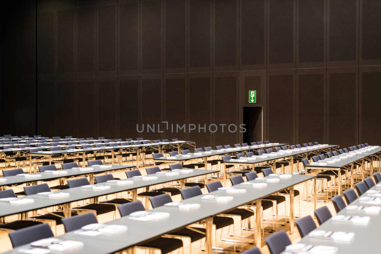 Closeup of a large empty conference room with handouts, papers and pens before meeting