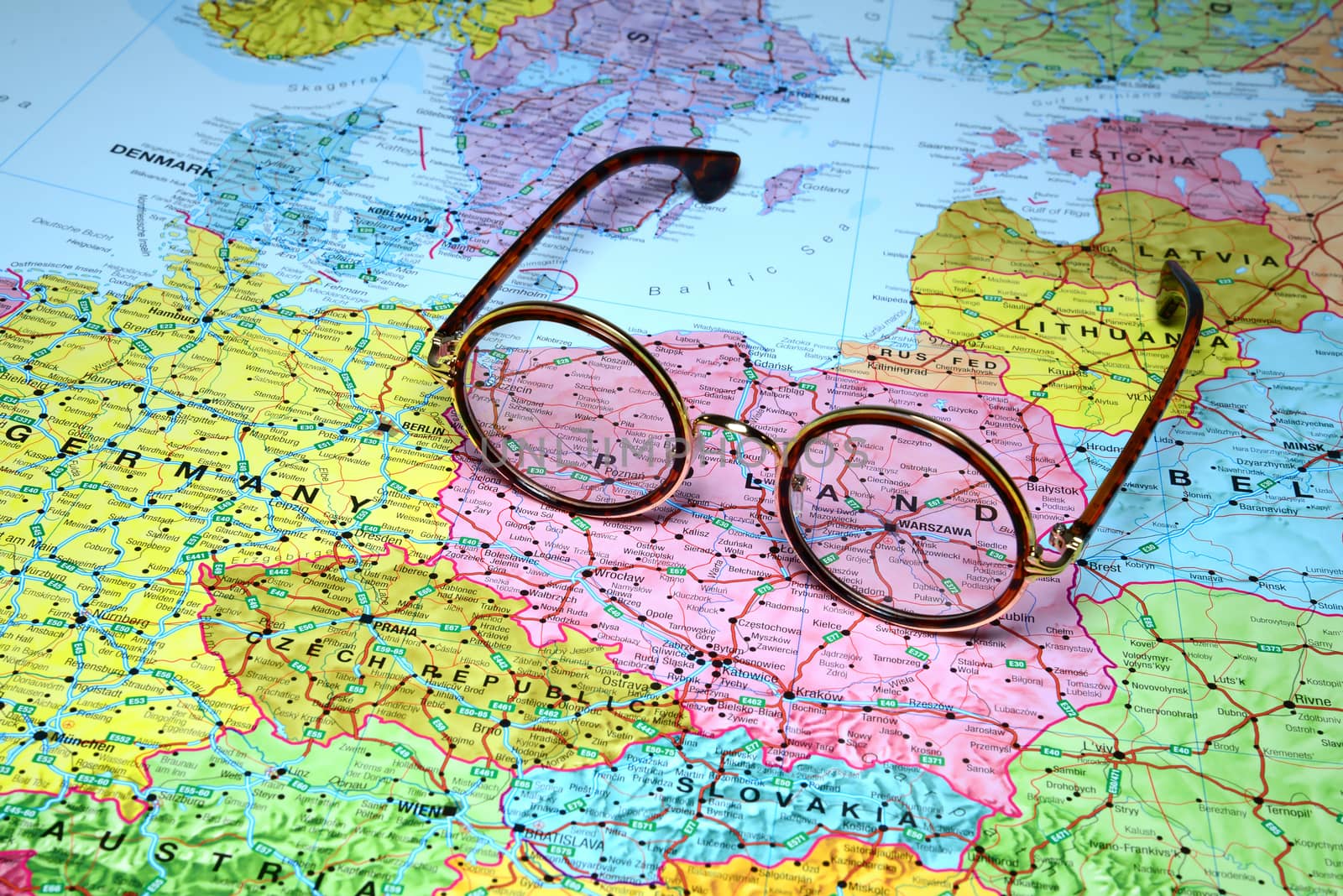 Photo of glasses on a map of europe. Focus on Warsaw, Poland. May be used as illustration for traveling theme.