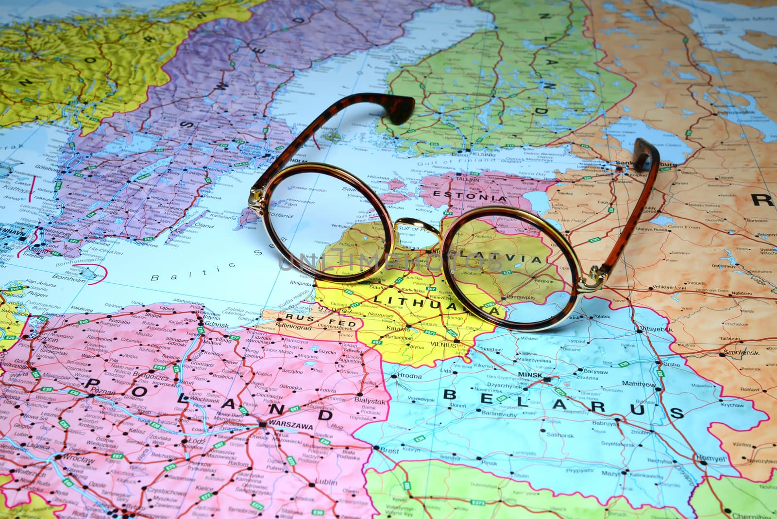 Photo of glasses on a map of europe. Focus on Latvia country. May be used as illustration for traveling theme.