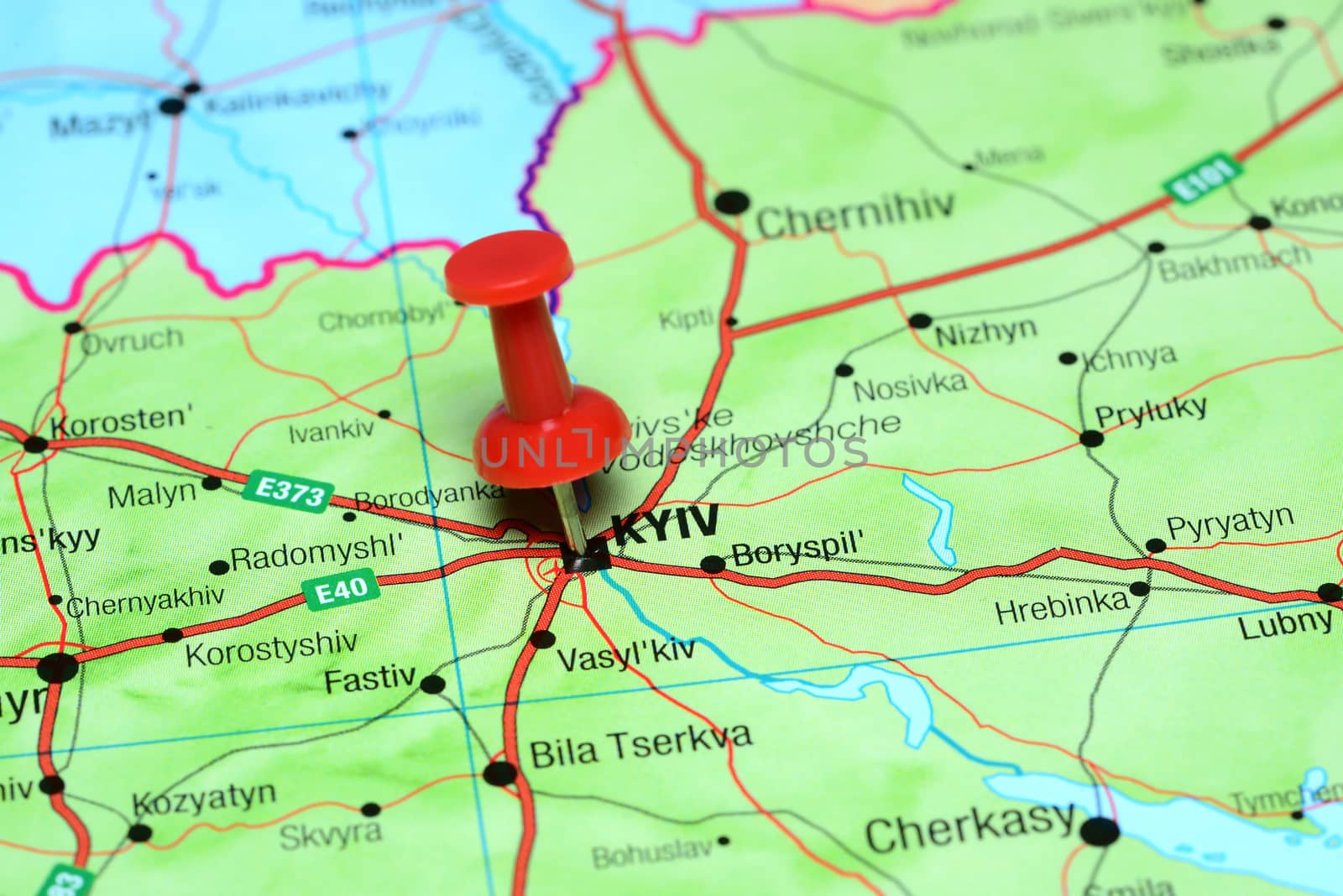 Photo of pinned Kyiv on a map of europe. May be used as illustration for traveling theme.