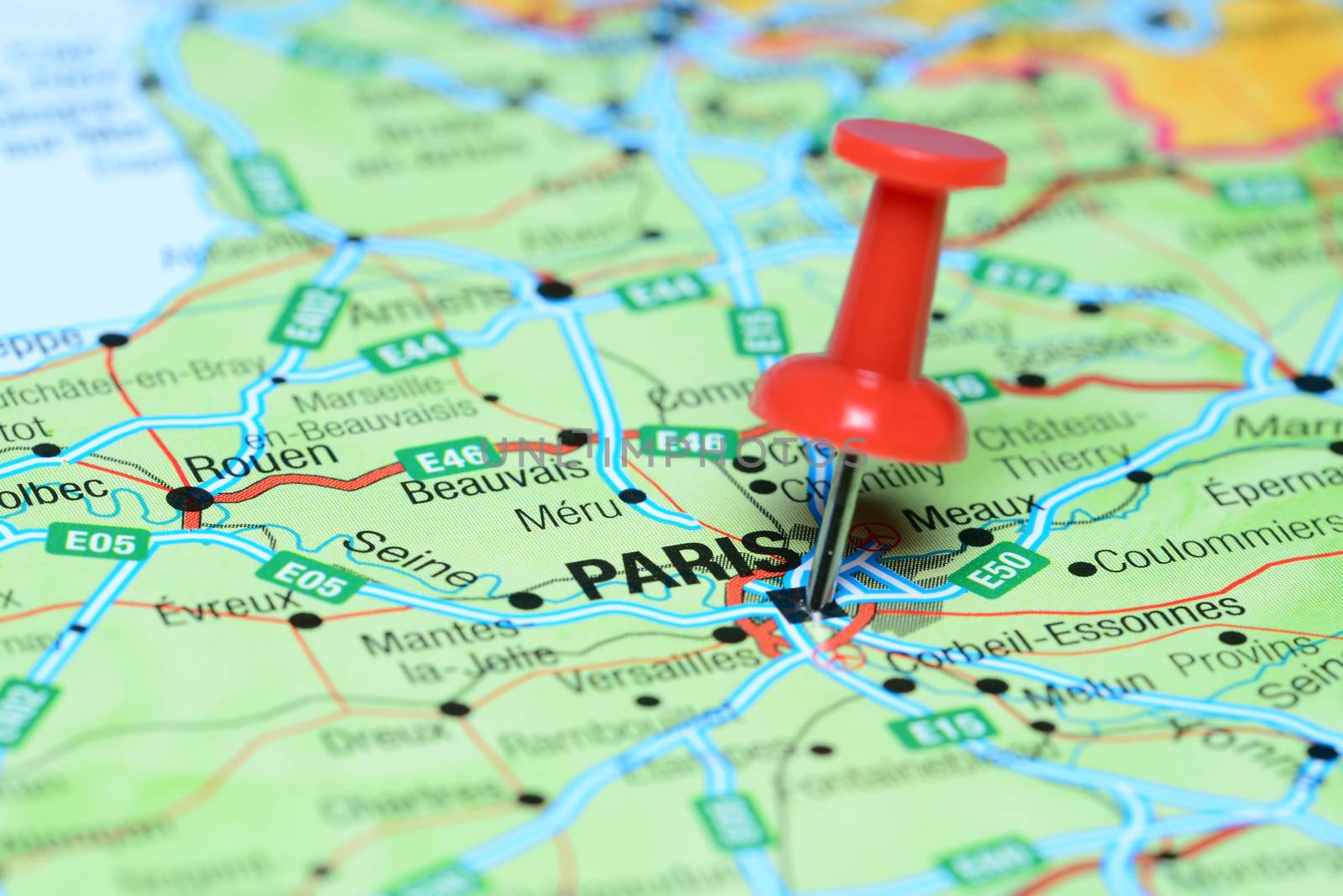Photo of pinned Paris on a map of europe. May be used as illustration for traveling theme.