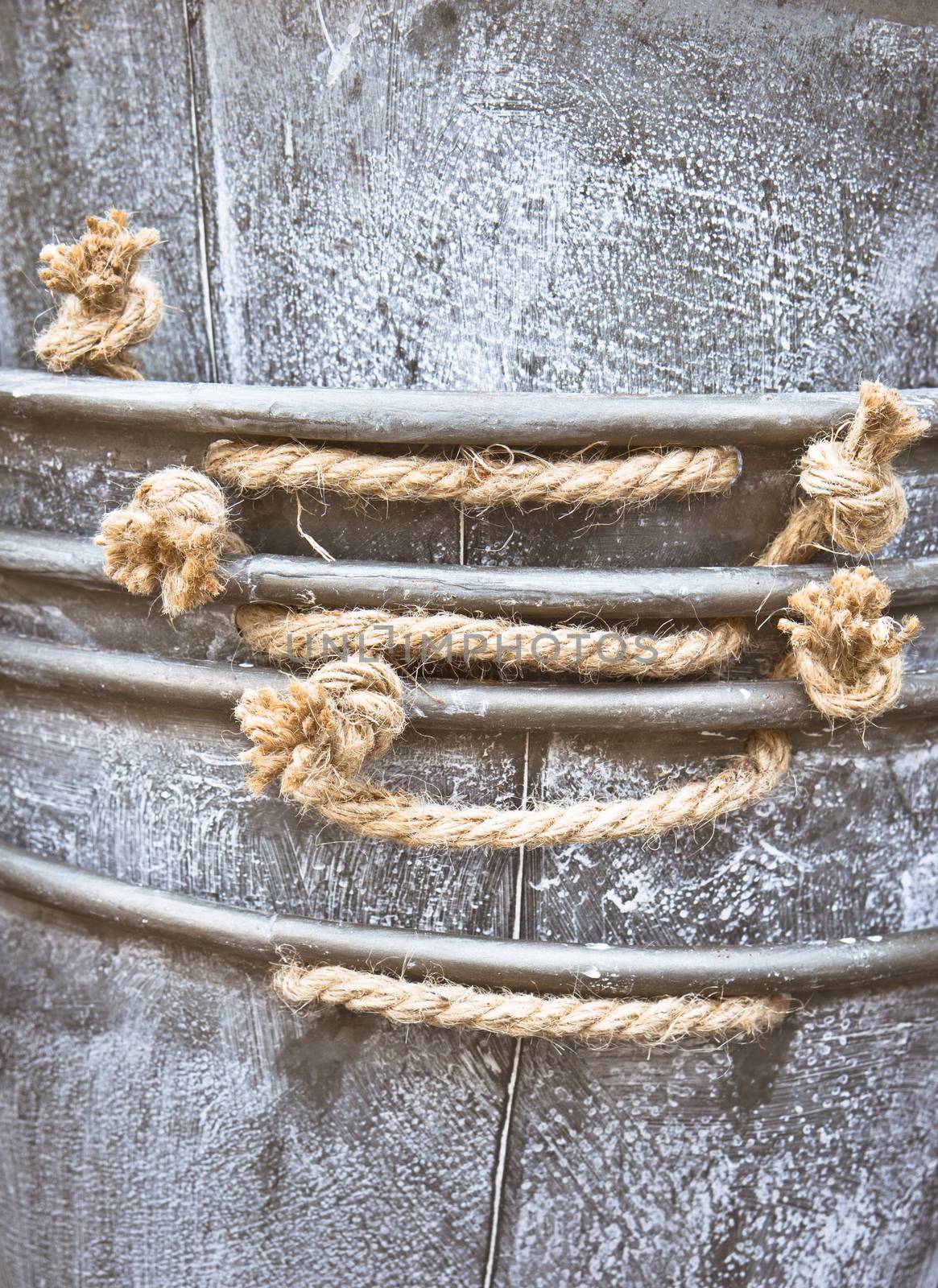 Close up of the edge of a pile of metal containers with rope handles