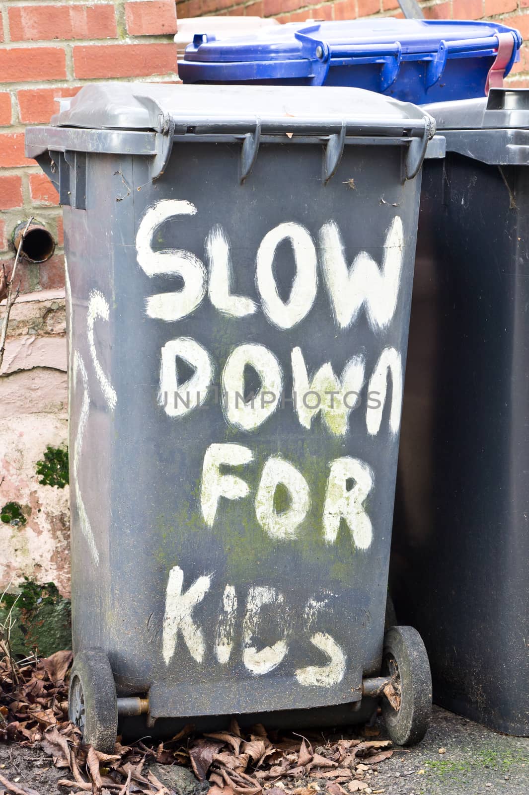 Slow down for kids written on a black bin