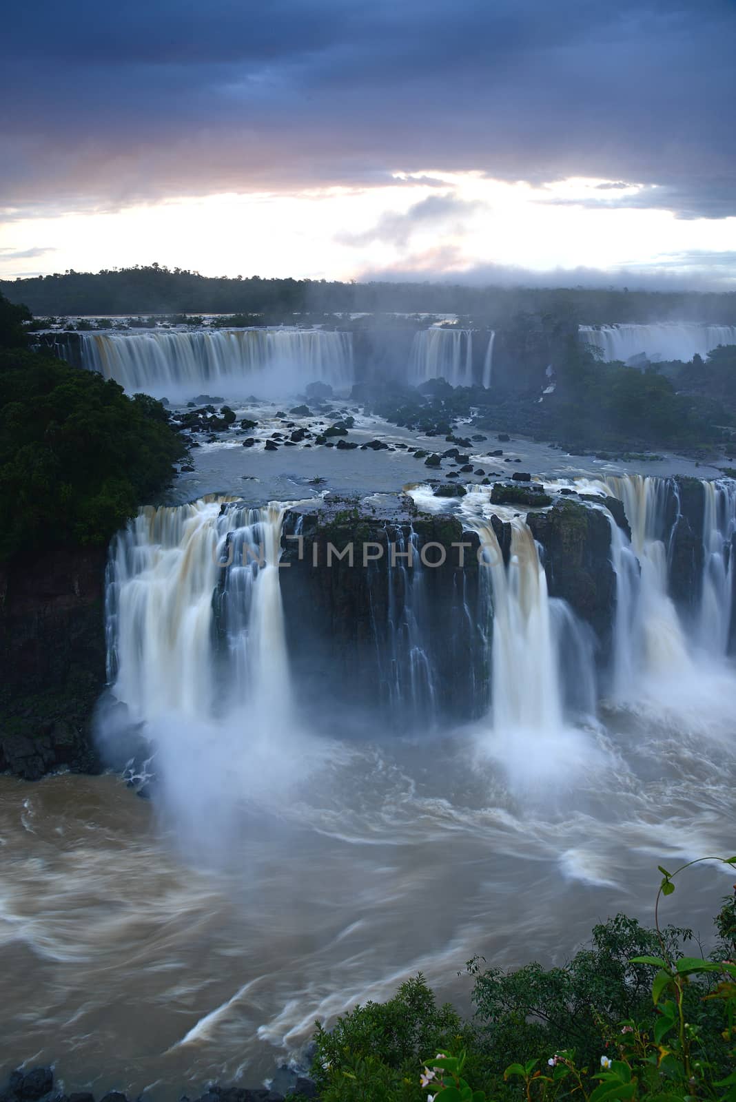 Iguazu waterfall in south americal tropical jungle with a massive flow of water