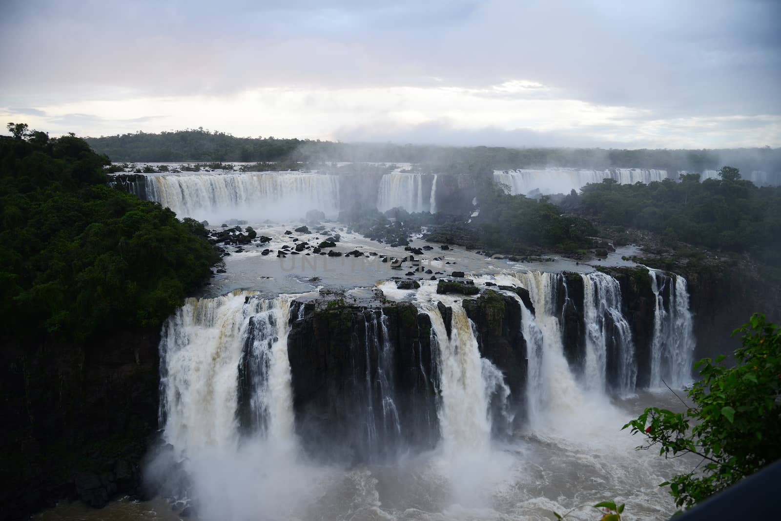 Iguazu waterfall in south americal tropical jungle with a massive flow of water