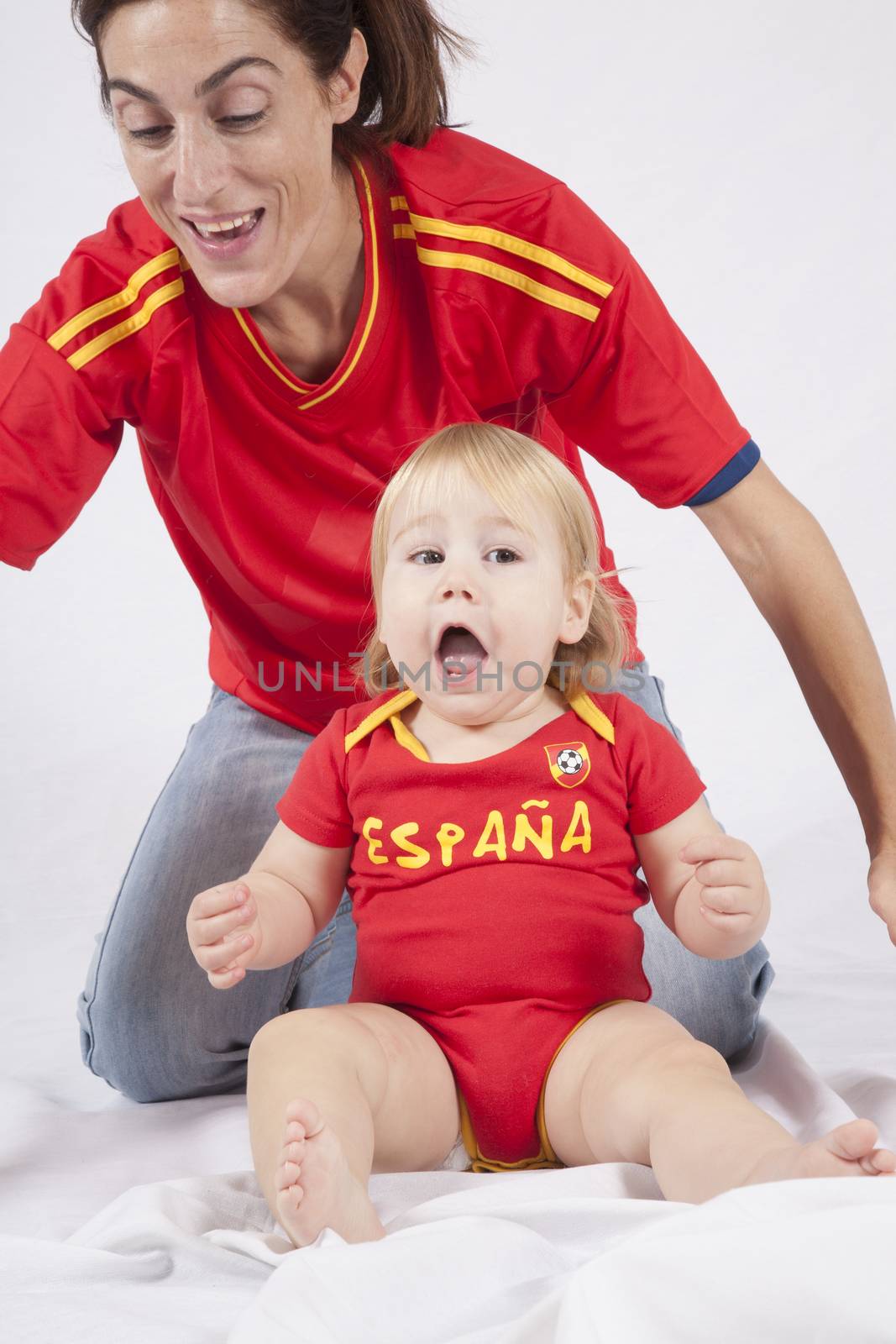 celebrating blonde baby sixteen month old with red shirt of Spanish soccer team and mother