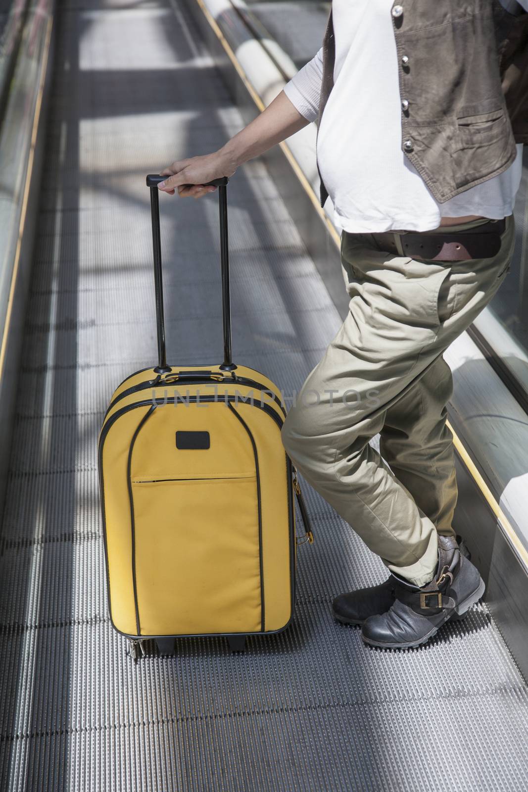 woman pregnant with yellow suitcase standing at walkway