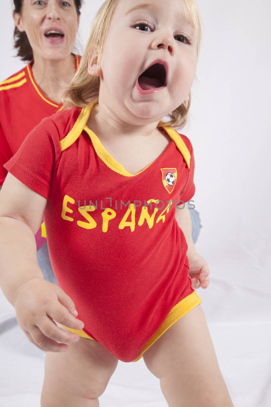 blonde baby sixteen month old and mother with red shirt of Spanish soccer team celebrating