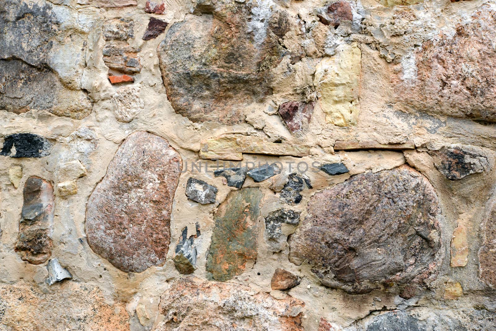 Photo of a colourful stone wall. May be used for texture and background.