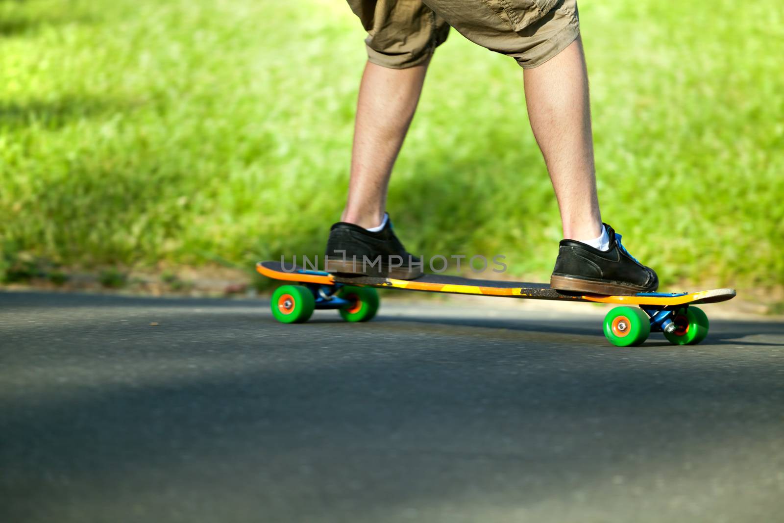 Action shot of a longboarder skating on a suburban road. Shallow depth of field. 