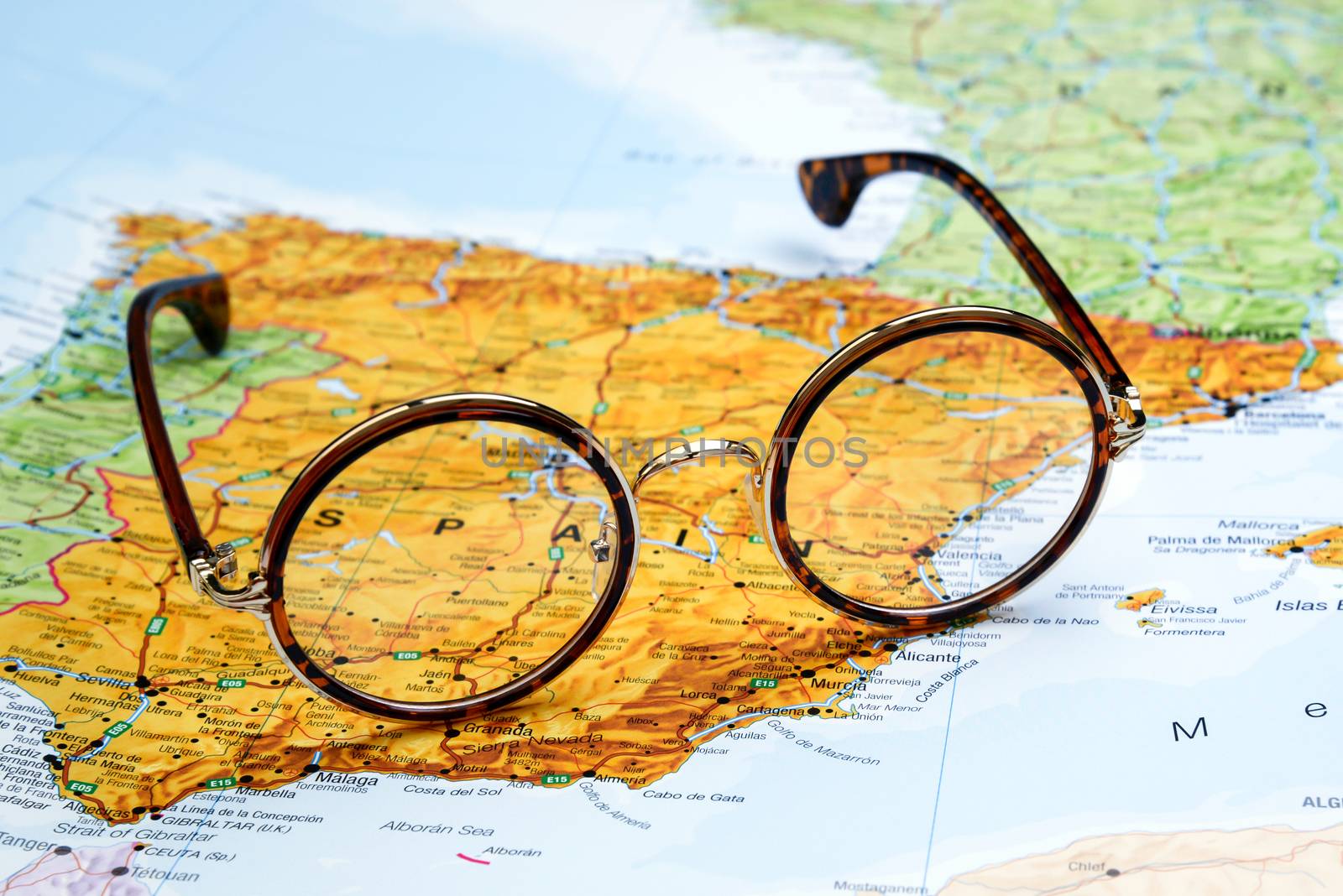 Photo of glasses on a map of europe. Focus on Spain. May be used as illustration for traveling theme.