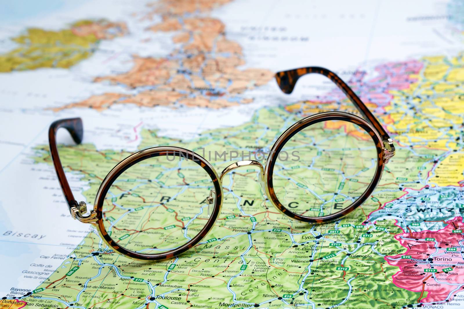 Photo of glasses on a map of europe. Focus on France. May be used as illustration for traveling theme.