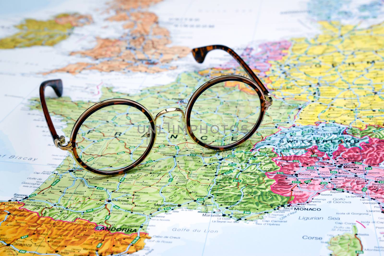 Photo of glasses on a map of europe. Focus on France. May be used as illustration for traveling theme.