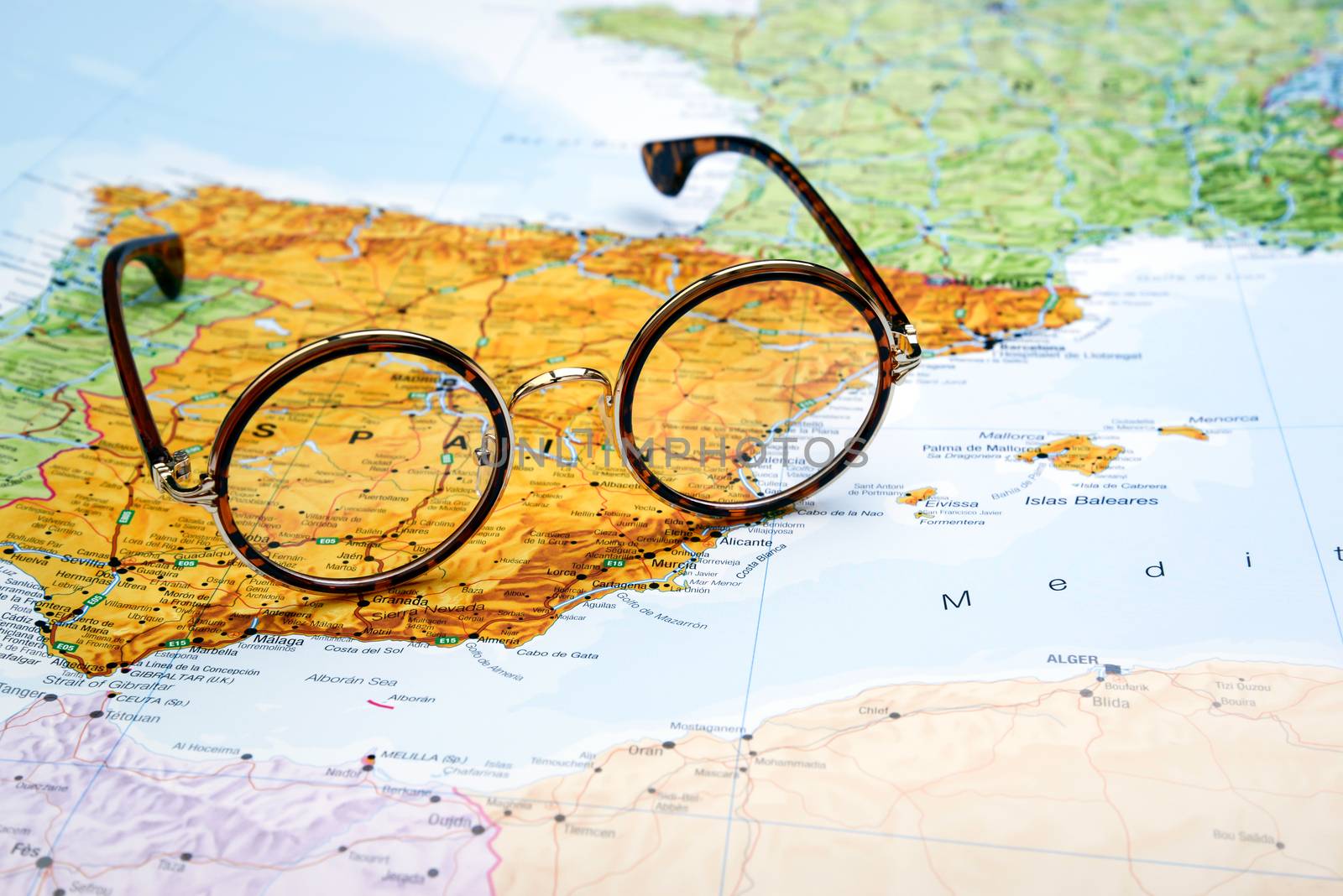 Photo of glasses on a map of europe. Focus on Spain. May be used as illustration for traveling theme.